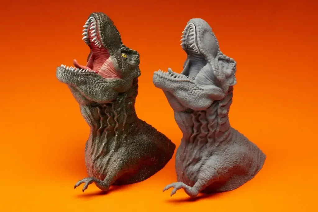 Блог пост - Еволюцията на 3D технологията и изкуството. Изображението показва две 3D фигури на динозаври. Едната боядисана, а другата не.