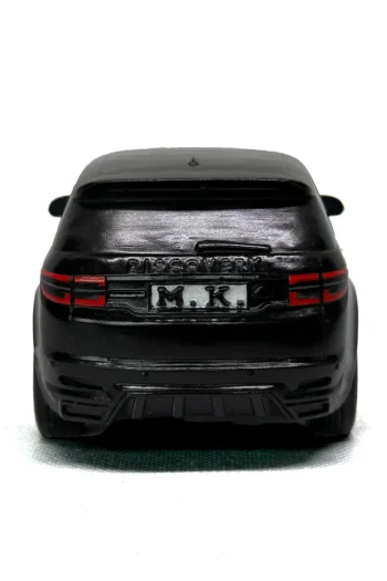 аден изглед на черна персонализирана 3D фигура на SUV с надпис „DISCOVERY“ и регистрационна табела „M.K.“ на бял фон.
