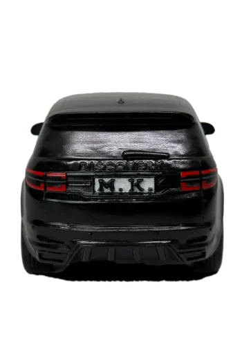 Заден изглед на черна персонализирана 3D фигура на SUV с надпис „DISCOVERY“ и регистрационна табела „M.K.“ на бял фон.